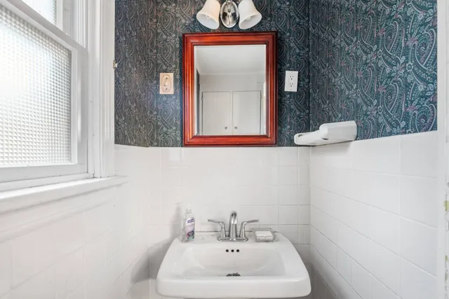 a bathroom with a sink a mirror and a window