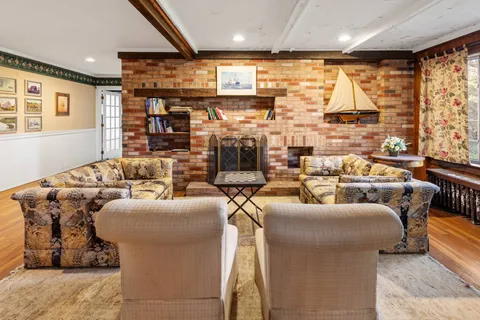 a living room with fireplace furniture and a large window