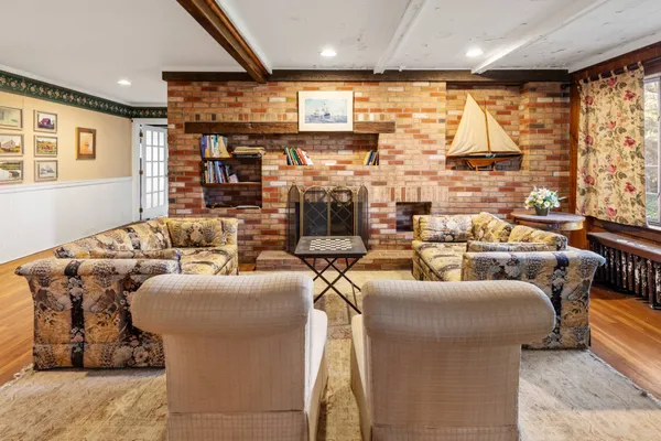 a living room with fireplace furniture and a large window