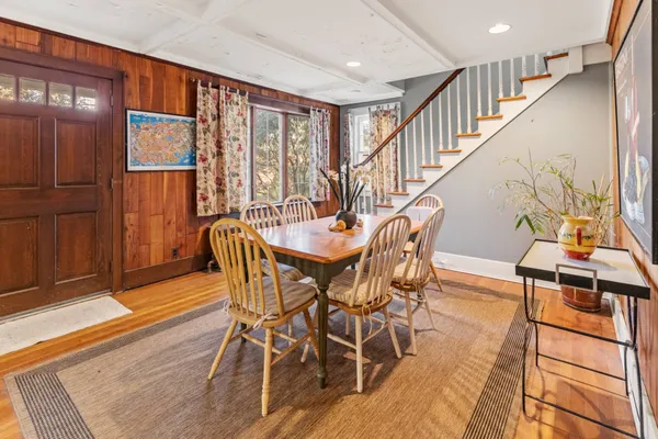 a dining room with furniture entryway and wooden floor