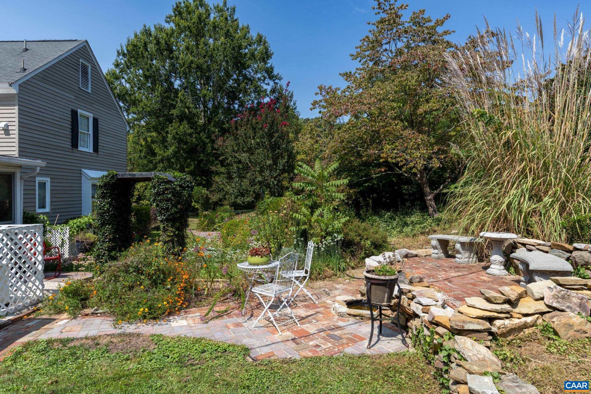1128 Beaverdam Road Keswick, VA 22947 - Photo 26 of 74 a view of backyard with table and chairs and a large tree
