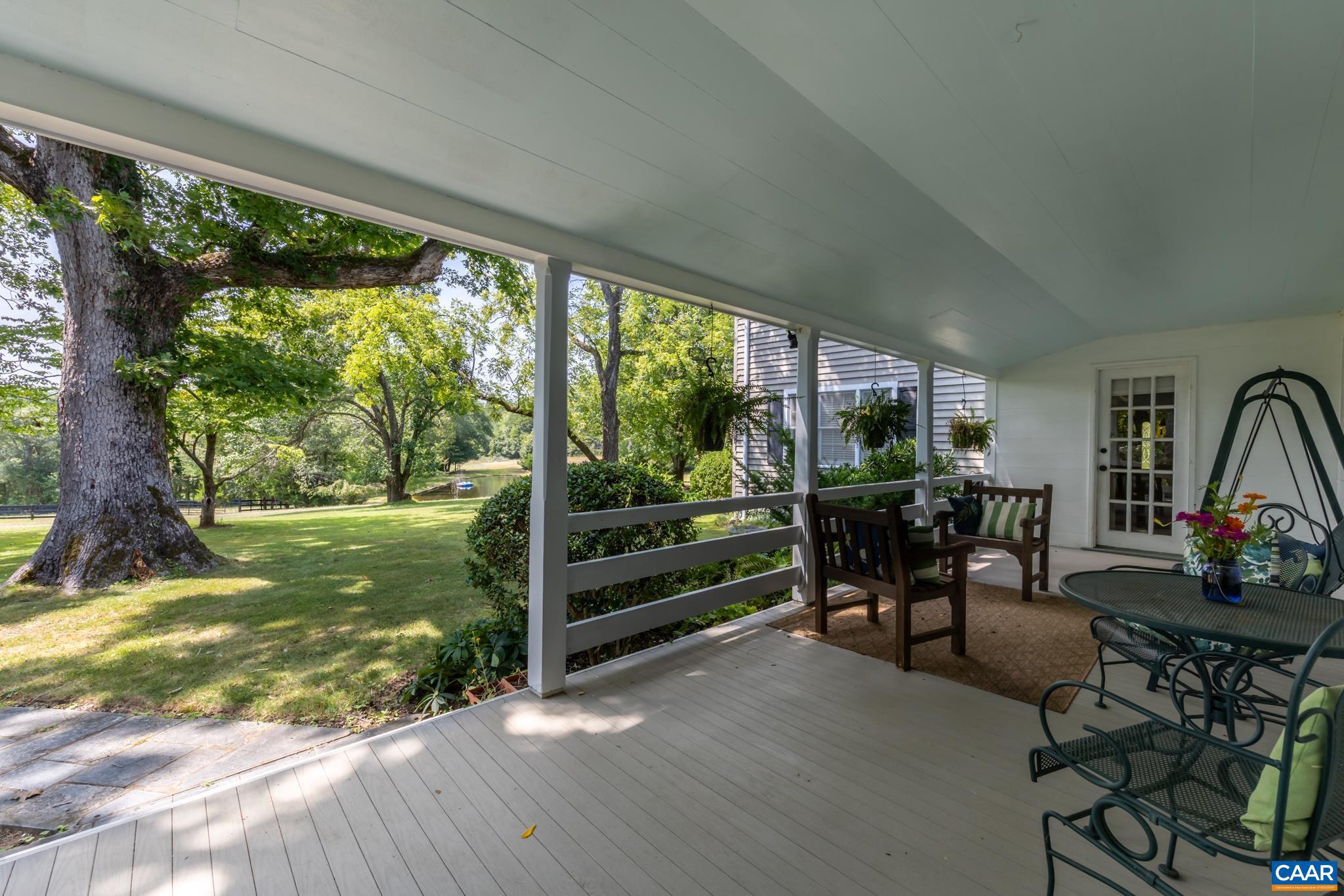 1128 Beaverdam Road Keswick, VA 22947 - Photo 28 of 74 a view of a patio with table and chairs potted plants with large tree