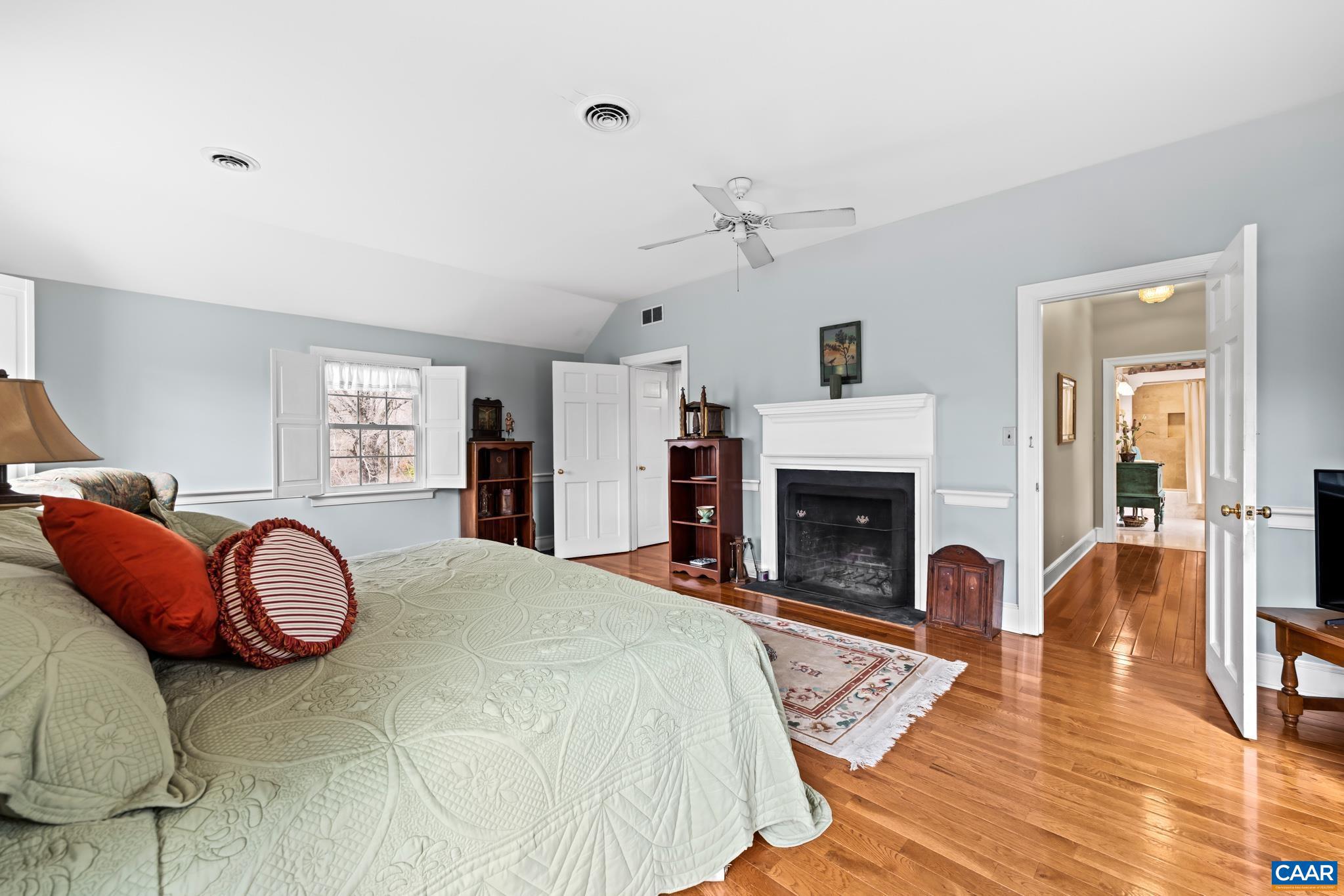 1128 Beaverdam Road Keswick, VA 22947 - Photo 65 of 74 a spacious bedroom with a bed and a fireplace