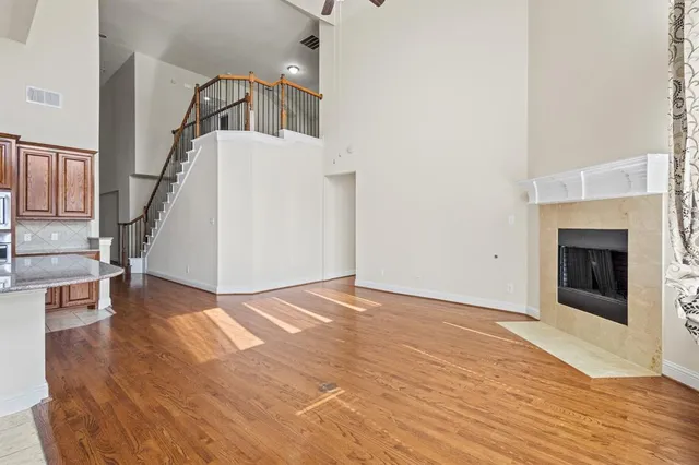 a view of a livingroom with wooden floor and staircase