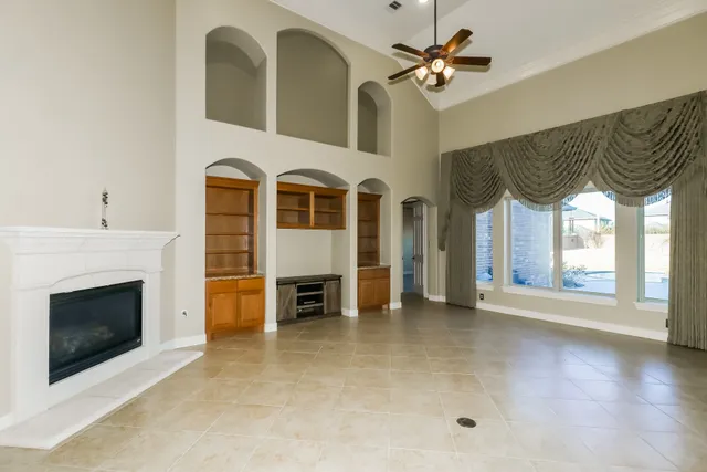 a view of a livingroom with an empty kitchen and a fireplace