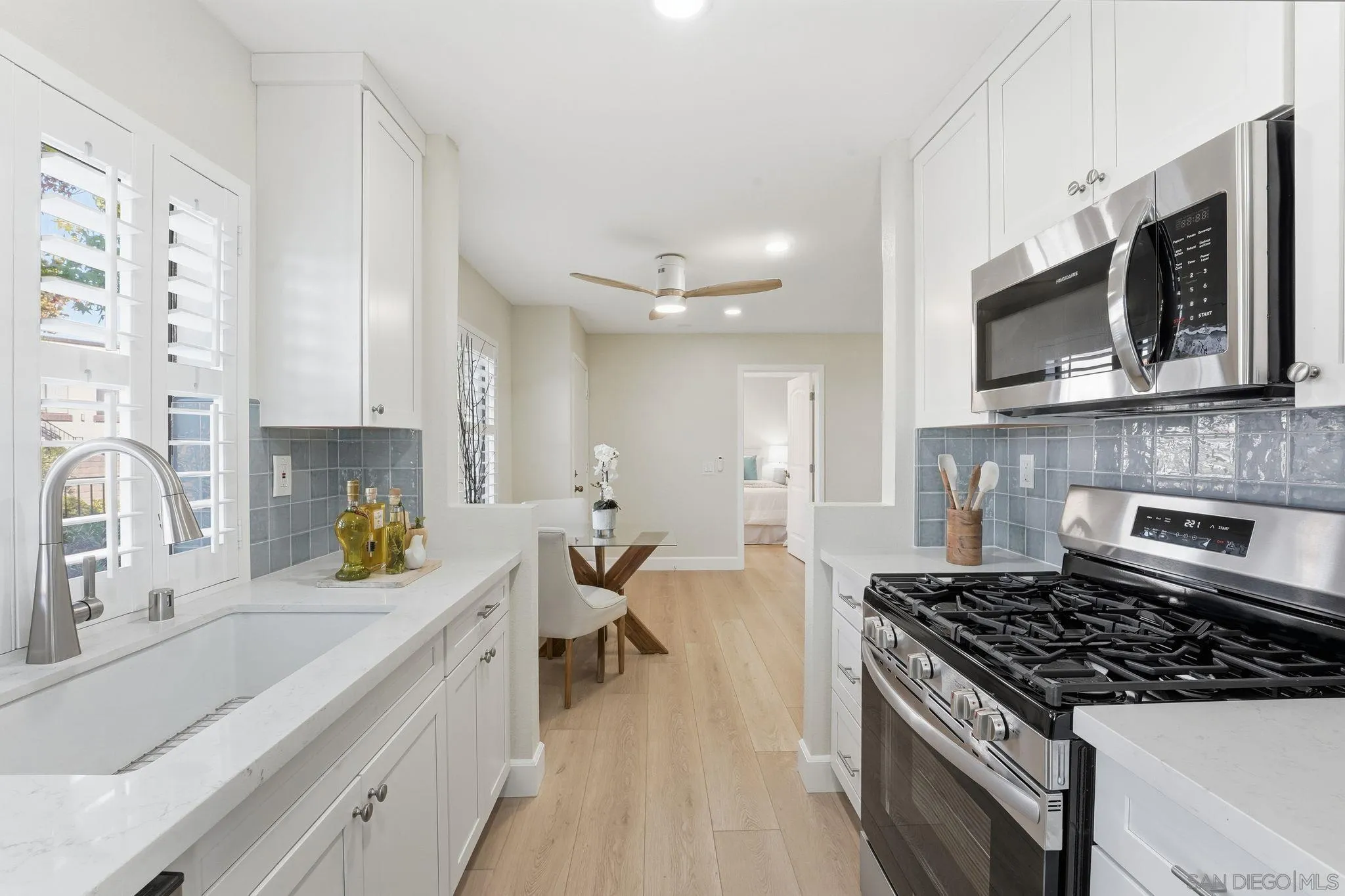 8480 New Salem Street, Unit 103 San Diego, CA 92126 - Photo 12 of 29 a kitchen with stainless steel appliances a stove a sink cabinets and a wooden floor