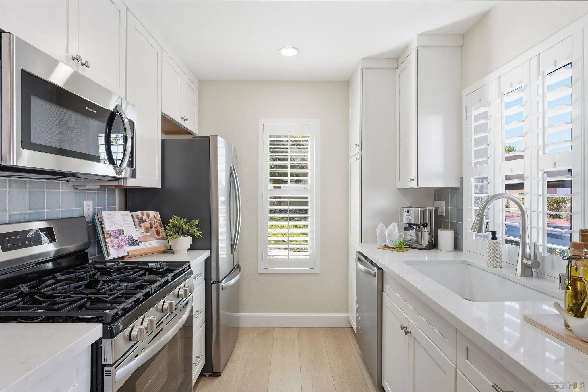 8480 New Salem Street, Unit 103 San Diego, CA 92126 - Photo 8 of 29 a kitchen with stainless steel appliances granite countertop a stove a sink and a microwave