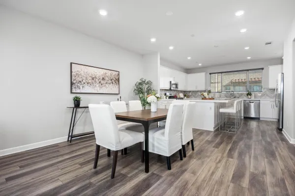 a kitchen with a dining table chairs and refrigerator