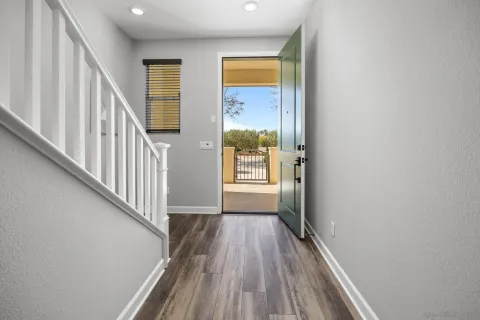 a view of a hallway with wooden floor and staircase