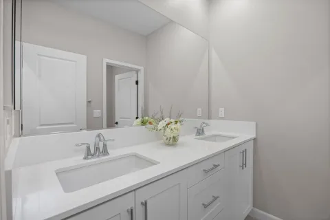 a bathroom with double sink and a mirror