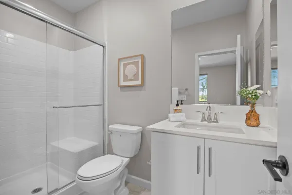 a bathroom with a sink a toilet and shower