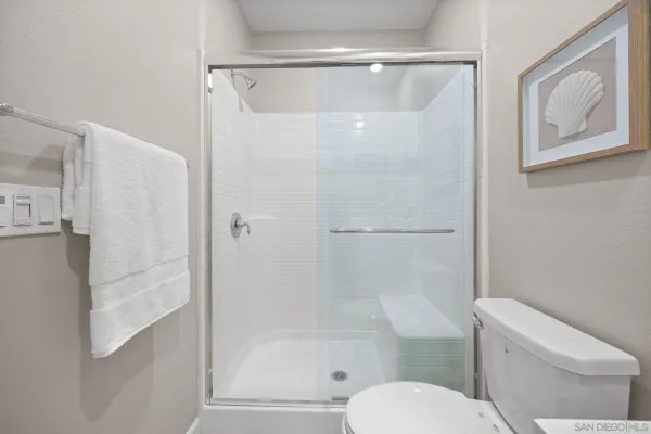 a white toilet sitting next to a bath tub shower