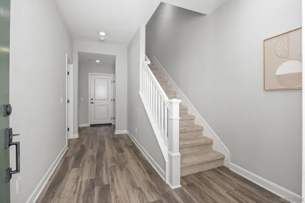 a view of a hallway with wooden floor and entryway