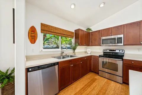 a kitchen with stainless steel appliances granite countertop a sink a stove and a microwave