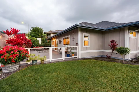 a front view of a house with a yard and potted plants