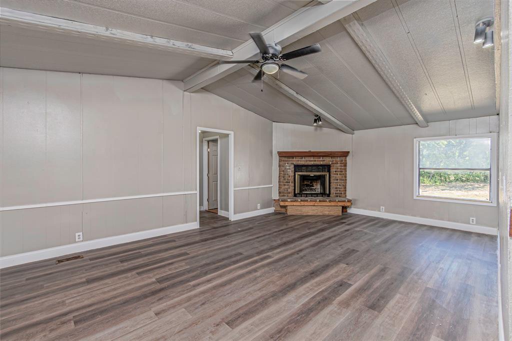 17381 Gaffield Road Justin, TX 76247 - Photo 11 of 38 a view of an empty room with wooden floor fireplace and a window