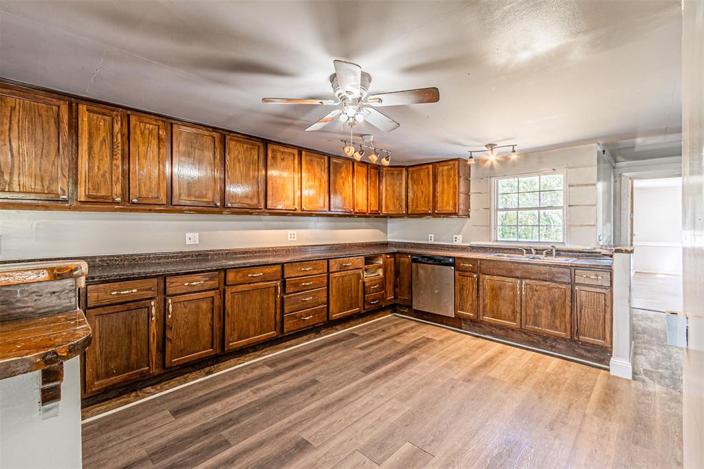 17381 Gaffield Road Justin, TX 76247 - Photo 15 of 38 a kitchen with stainless steel appliances granite countertop wooden cabinets a sink a stove a dining table and chairs