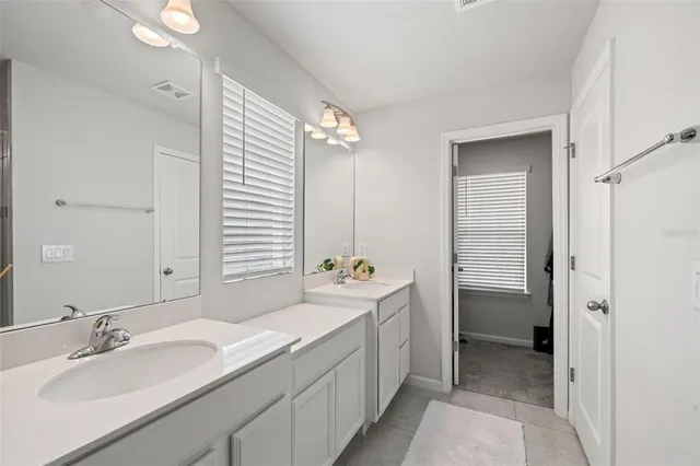 a spacious bathroom with a double vanity sink mirror and bathtub