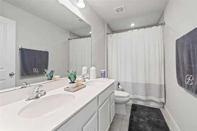 a bathroom with a double vanity sink mirror and toilet