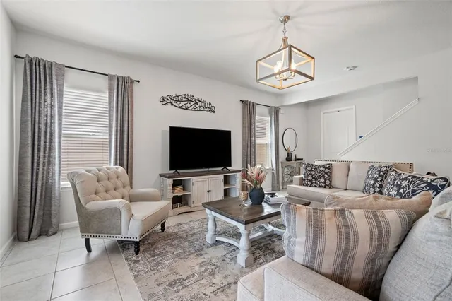 a living room with furniture a flat screen tv and a window