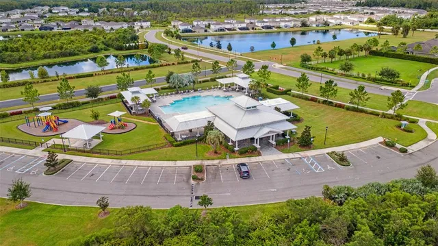 an aerial view of residential houses with outdoor space and parking
