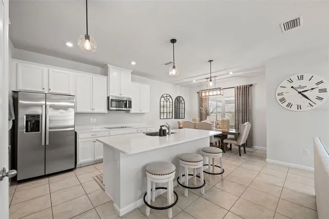 a kitchen with stainless steel appliances granite countertop a sink a stove and a refrigerator