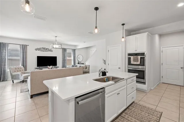 a large white kitchen with a stove a sink and a refrigerator