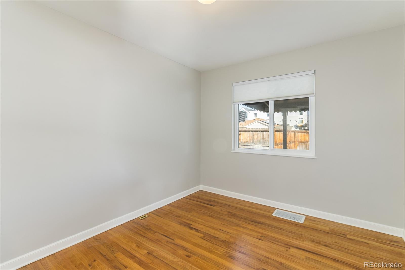 3040 Cook Street Denver, CO 80205 - Photo 15 of 19 a view of an empty room with wooden floor and a window