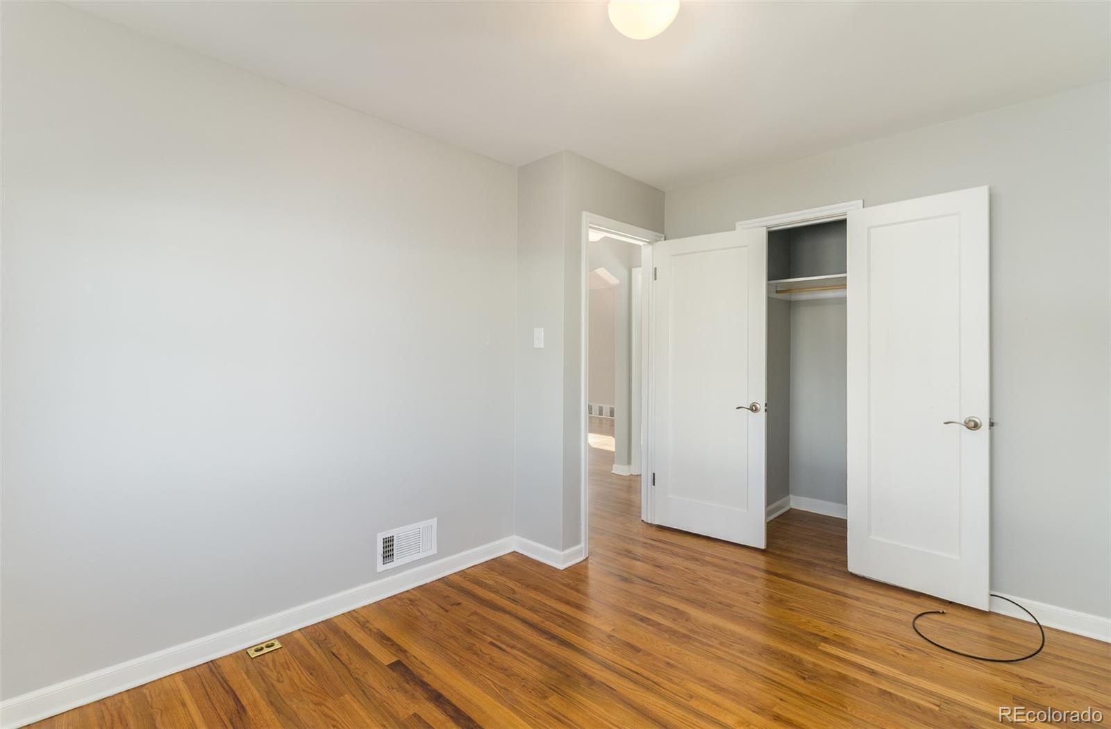3040 Cook Street Denver, CO 80205 - Photo 18 of 19 a view of an empty room with wooden floor and closet