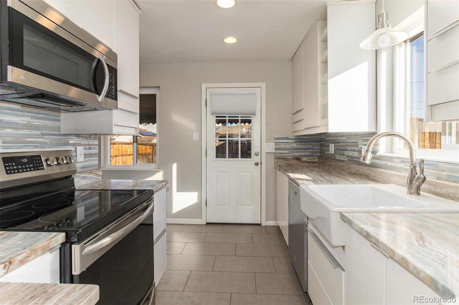 3040 Cook Street Denver, CO 80205 - Photo 4 of 19 a kitchen with stainless steel appliances granite countertop a sink and a stove