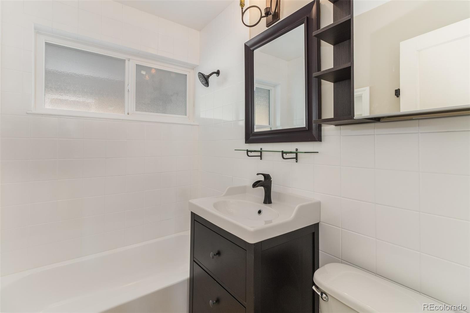 3040 Cook Street Denver, CO 80205 - Photo 6 of 19 a bathroom with a sink a toilet and mirror