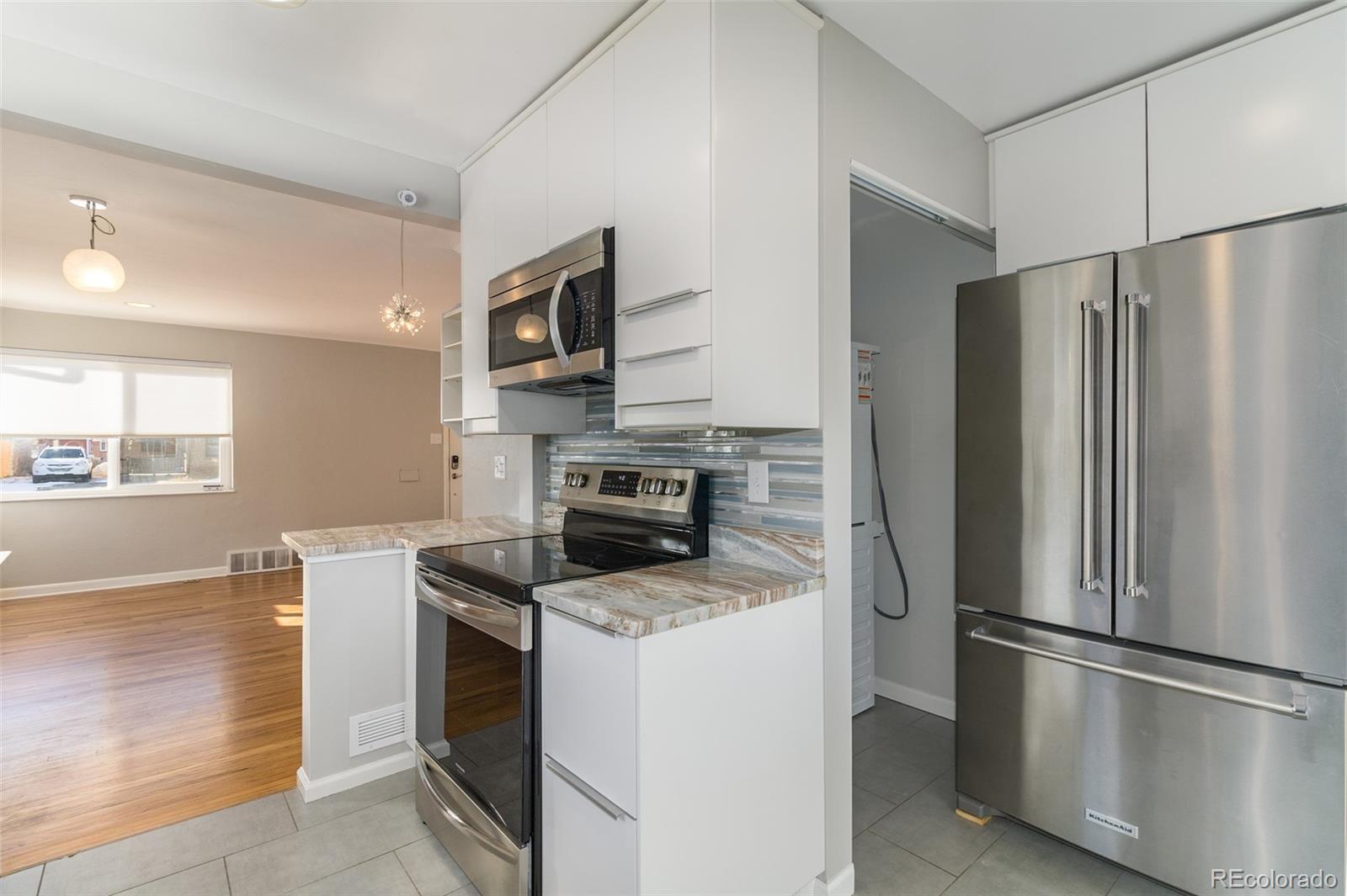 3040 Cook Street Denver, CO 80205 - Photo 8 of 19 a kitchen with stainless steel appliances granite countertop a refrigerator stove and microwave