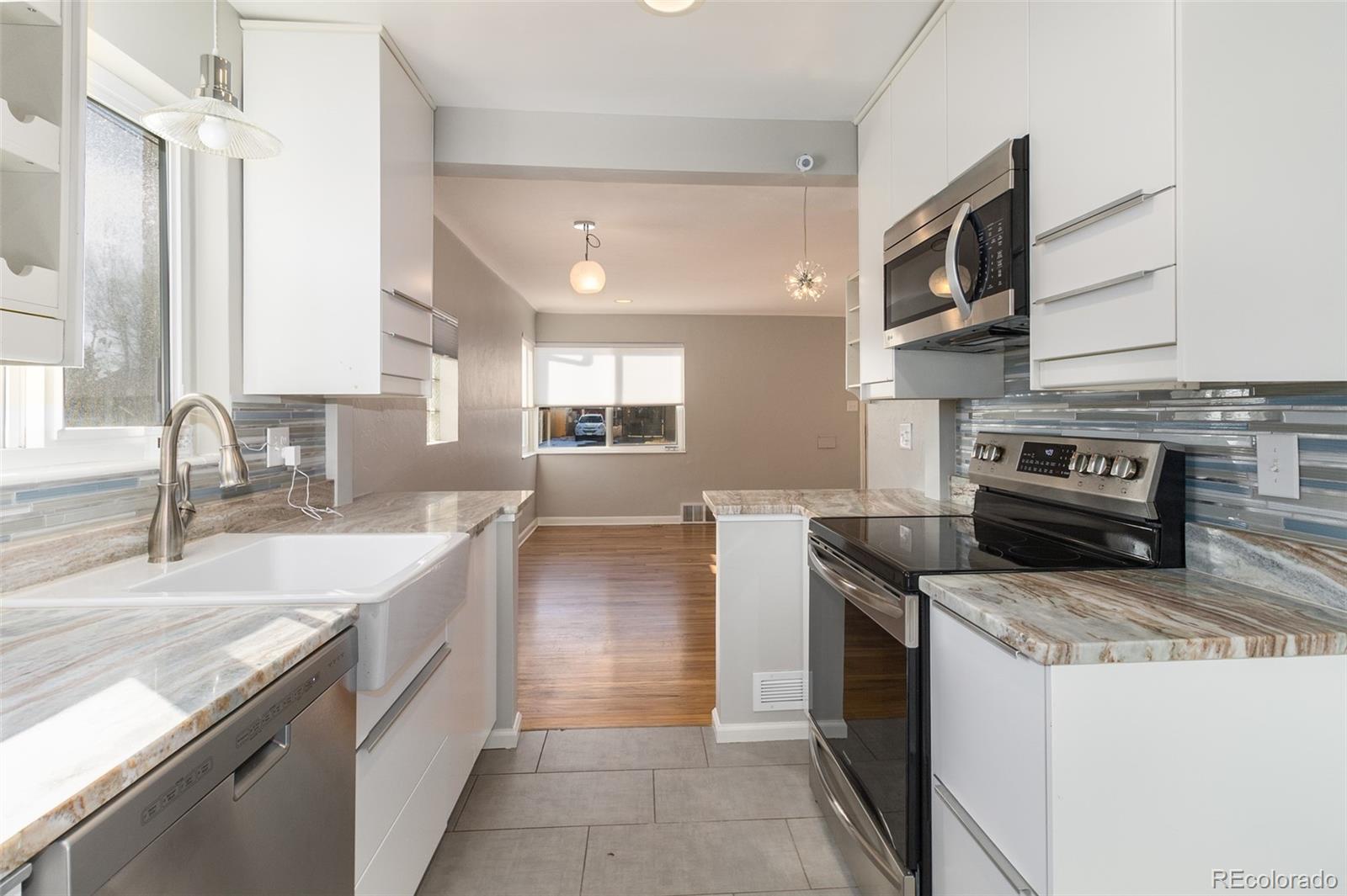 3040 Cook Street Denver, CO 80205 - Photo 9 of 19 a kitchen with stainless steel appliances granite countertop a sink a stove and a refrigerator