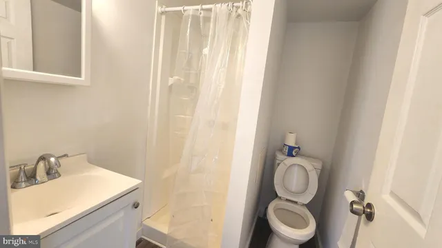 a bathroom with a sink a toilet and a mirror