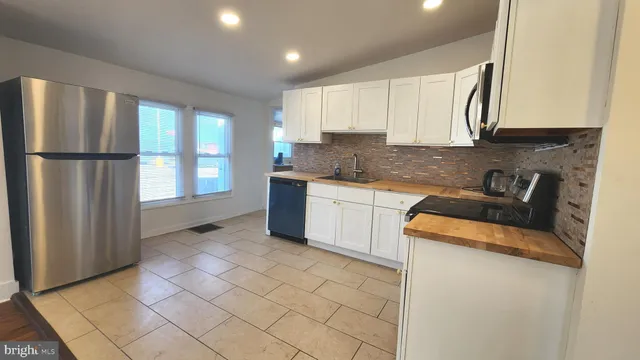 a kitchen with stainless steel appliances granite countertop a refrigerator sink and cabinets
