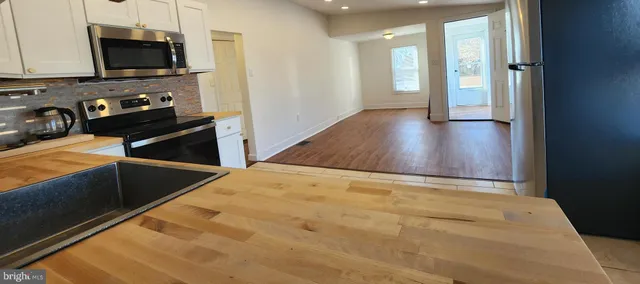 a view of a kitchen with wooden floor and a sink