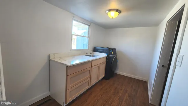 a utility room with wooden floor washer and dryer