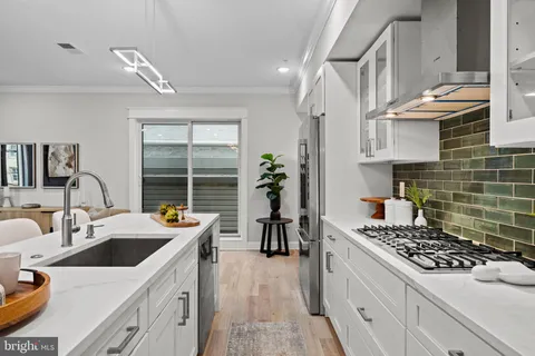 a kitchen with a stove and a white wooden cabinets