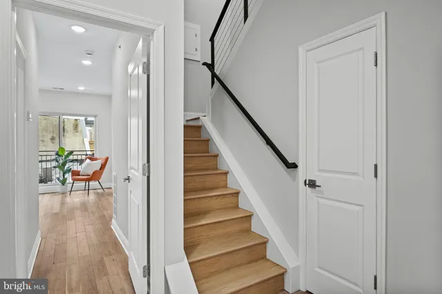 a view of a hallway with wooden floor and staircase