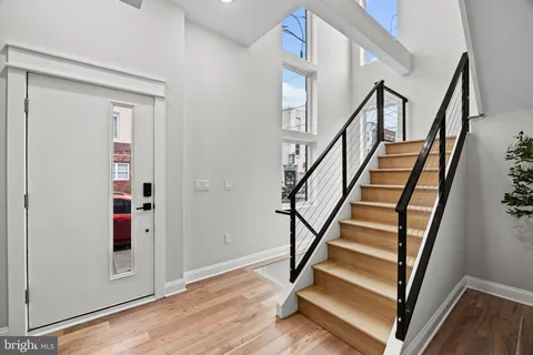 a view of entryway with wooden floor and stairs