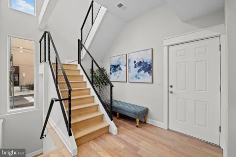 a view of a hallway with wooden floor and stairs