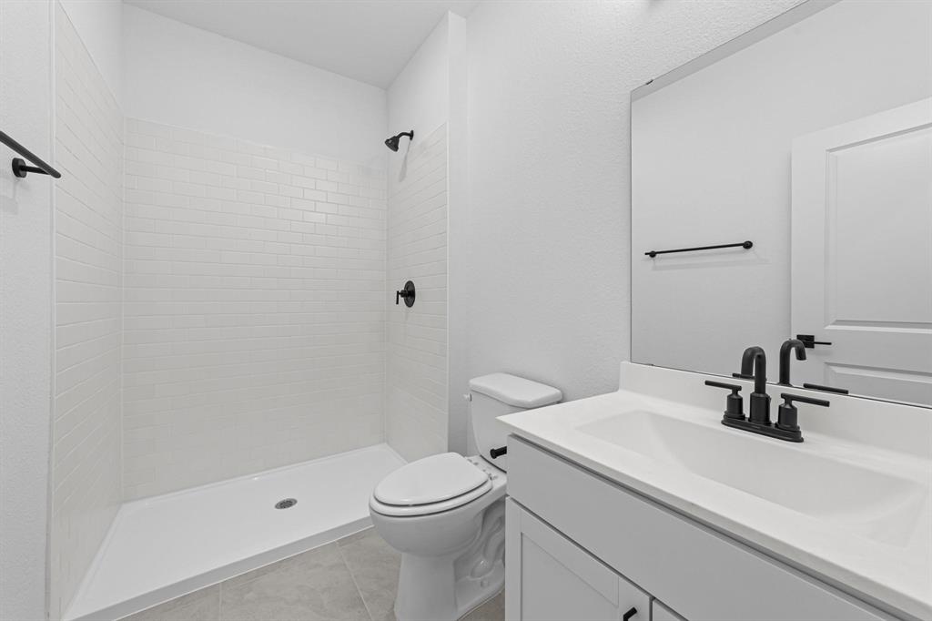 1509 Hamilton Street Howe, TX 75459 - Photo 17 of 23 Full bath featuring tile patterned floors, vanity, toilet, and tiled shower