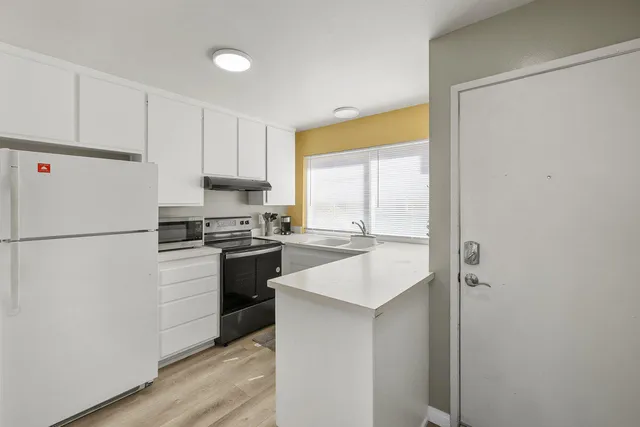 a kitchen with a refrigerator a stove a sink and a window