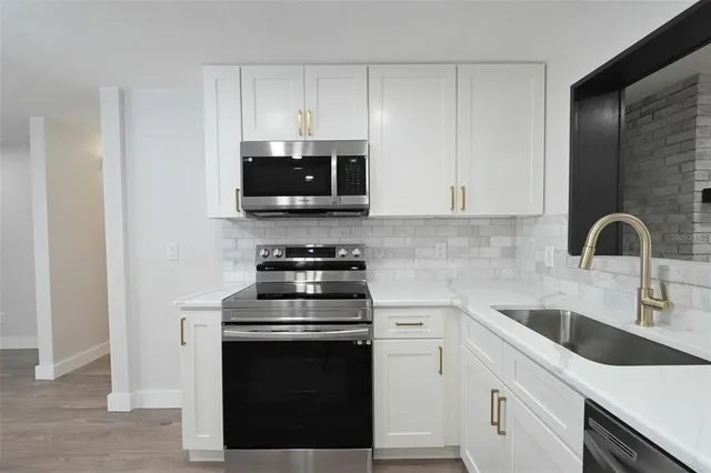 a kitchen with a sink and steel appliances