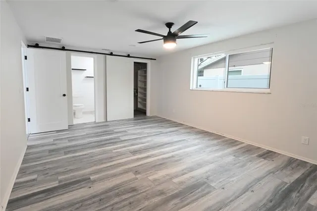 a view of a livingroom with wooden floor and a ceiling fan