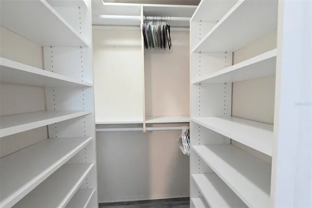 a view of walk in closet with empty racks