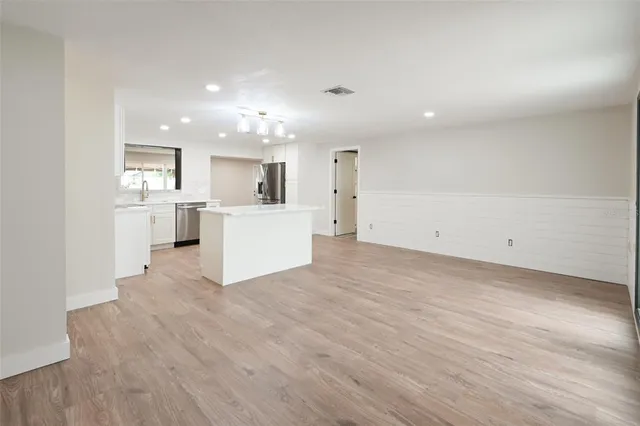 a view of a kitchen with a sink and dishwasher a refrigerator with wooden floor