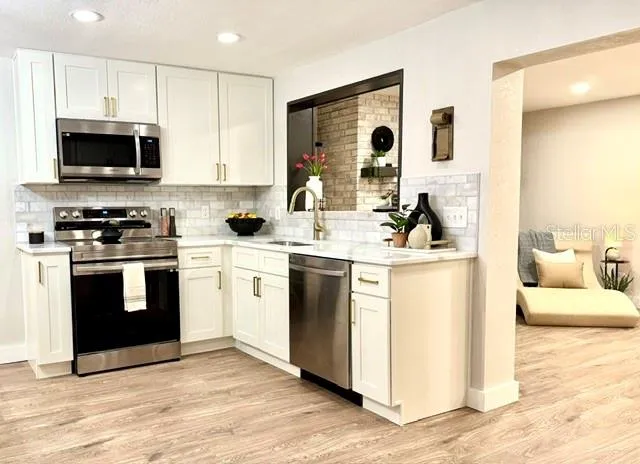 a kitchen with stainless steel appliances a stove microwave and sink