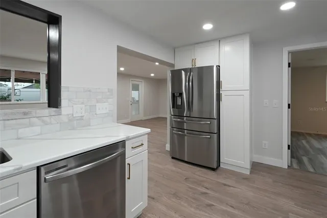 a kitchen with stainless steel appliances granite countertop a refrigerator and a sink