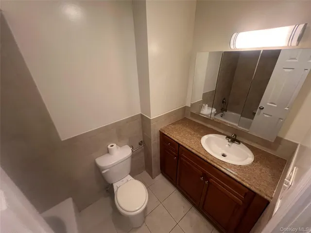 a bathroom with a granite countertop toilet sink and mirror